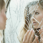 mujer frente a espejo roto sin autoestima